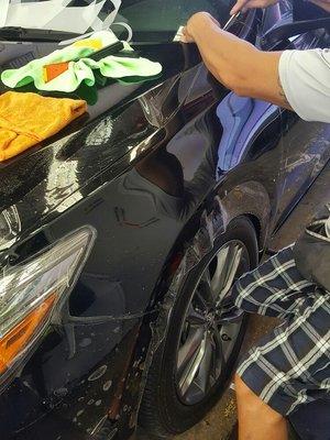 Julius is cutting out a fender for paint protection.