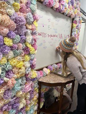 Brides get to sign the flower wall when they buy a dress