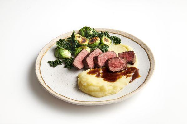 Deliciously tender NY Strip with buttery whipped potatoes, roasted vegetables & cabernet demi