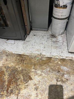 Water leaking from our furnace that destroyed the floors outside our utility closet.