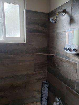 Shower with amenities, body wash, shampoo, conditioner.