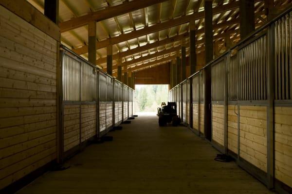 Beautiful aisleway with horse stalls by Spane Buildings Inc.