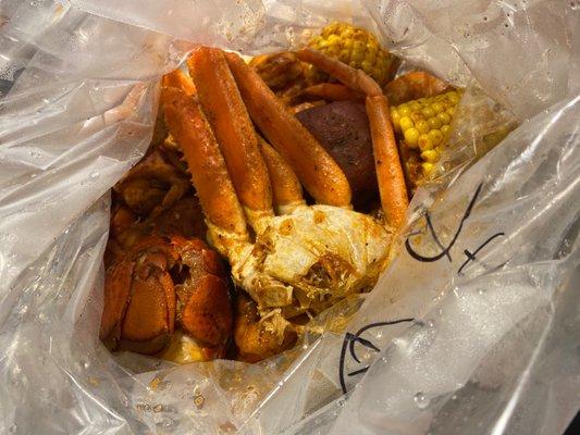 Inside the bag look at my lobster  tail special, crab  legs, shrimp, sausage, corn  , & potatoes