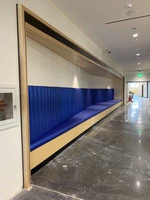 A custom-built banquette with a channeled back upholstered in a blue vinyl at a fine arts center.