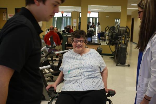 Client being helped into our seated stepper machines.