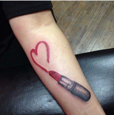 Realistic Mac red lipstick drawing a heart on the left forearm in color