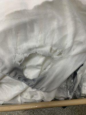 This is the soiled and ripped mattress pad. Additional photo of tears