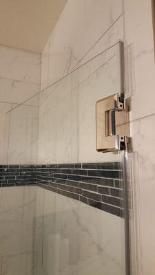 Seamless shower door. Polished Nickel, two way hinges and Diamond Blue Sealant finish.