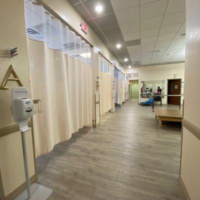 Entrance into the larger Physical Therapy area with weights, mirrors and more individual treatment rooms.