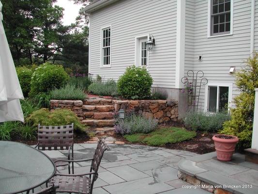 Back Patio with herb garden and steps to garage and drive