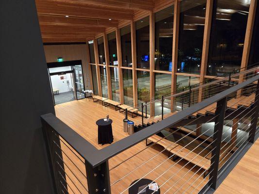 Looking down from the upper level to the entry hall and doors.