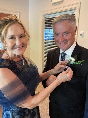 Mother of the bride pinning on father of the bride's boutonniere.