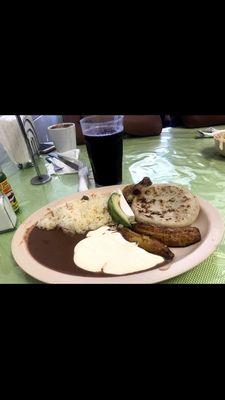 This is a breakfast dish that comes with pupusas fried plantains, beans, rice, and Salvadoran cream.