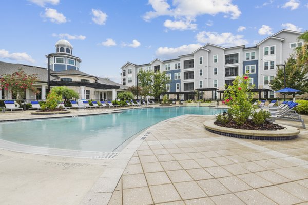 Image of resort-style pool with sundeck and lounge chairs at Lantower Asturia.