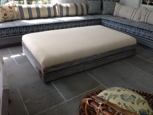 Custom ottoman built out of reclaimed wood, 2 cedar stained sofas bases with french style mattress cushions.