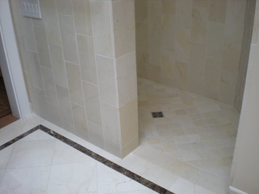 Marble pony wall and shower floor detail with Emperador dark marble inlay and schlueter drain system