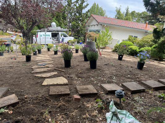 Planting flowers and shrubs making a Arizona flagstone walkway new landscaping