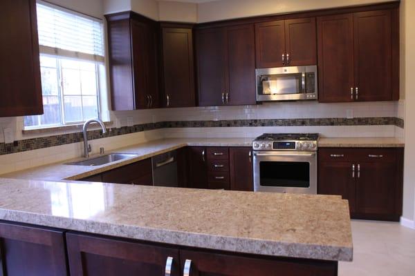 Starmark Cabinetry, Cambria Quartz countertops, subway tile backsplash with a strip of mixed-material accent tiles