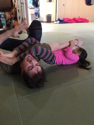 Coach Tyler repping a straight armbar with my daughter.