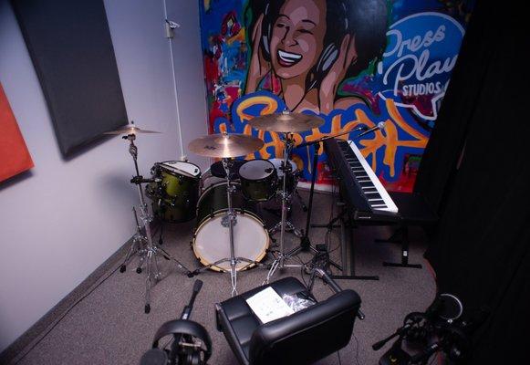 Rehearsal Space showcasing drum and keyboard area at Press Play Studios.