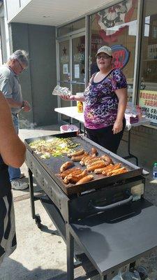 They cook sausage and pepper on a flat grill in front of the store every Friday