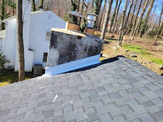 residential roof shingle with capping around the chimney.