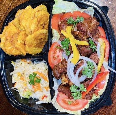 Delicious Griot(Fried Pork) topped with fresh Pikliz and fresh fried plantains on the side!