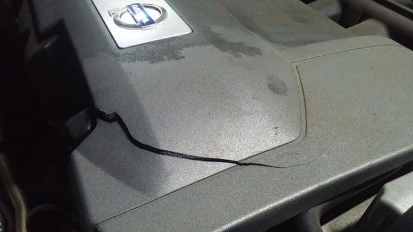 While checking window washer fluid,  discovered crack on my Volvo XC90 engine cover!  I had spark plugs replaced by them.