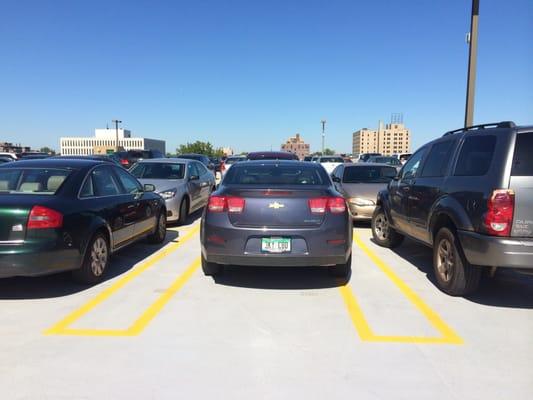 Spaces are so small I don't see how anyone can fit between the inner yellow lines.