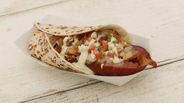 Popper Dog - Jalapeno sausage stuffed with pepper jack cheese, bacon, and crispy onions. Pico de gallo and guacamole, in a flour tortilla.