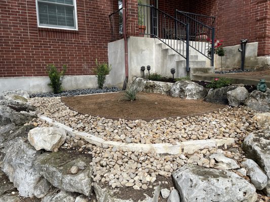 Xeriscaping on existing flowerbed made of boulders. We built a chopped limestone rock flowerbeds on top of it and installed a xeriscaping.