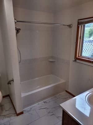 Remodeled bathroom, flooring, paint, tile, countertop, shower bar, faucet, shower valve.