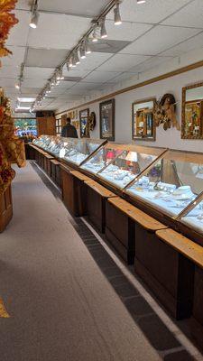 Large jewelry display case along far wall of store.