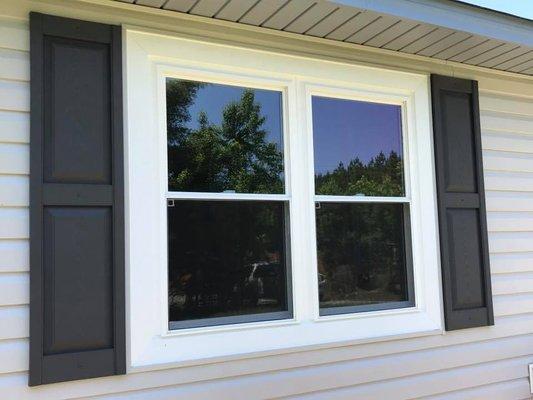 Installed, capped and caulked with vinyl shutters