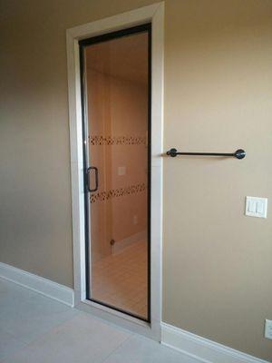 Semi-frameless single door with through glass handle. Installed using clear glass and oil rubbed bronze hardware.