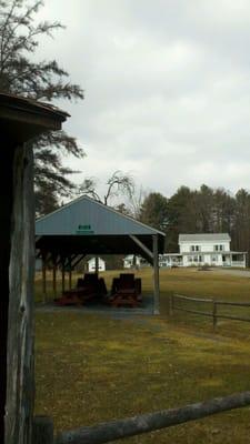 Picnic shelter with farmhouse in background.