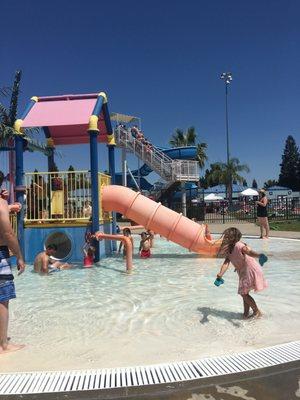 Kids play space with beach entry, 48" height minimum slide in background.