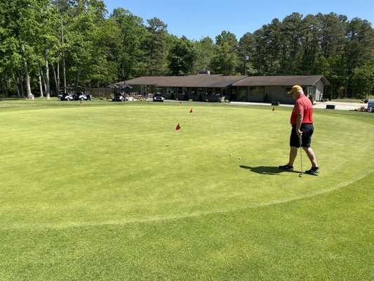 Practice green with Pro Shop & Pub in background.