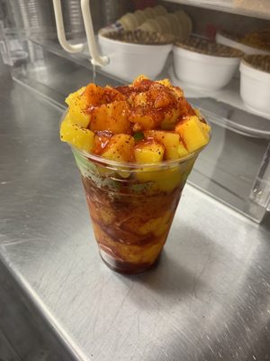 Mangollada with mango and lime ice cream topped with mango fruit, lime , chamoy and Tajín