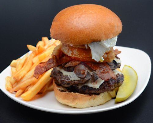 The Yard Burger, 1 lbs Angus beef, cheese, sauteed mushrooms,  bacon, onion rings topped with a fried egg on a brioche bun