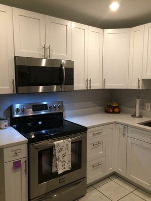 White quartz counters with shaker white cabinets, stainless steel farm sink! All by Rays Granite