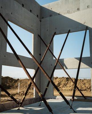 A view of the frame of a building from the inside looking out of holes that will eventually have windows in them.