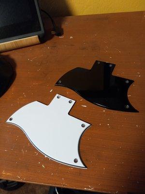 The original white pickguard and the custom black pickguard.