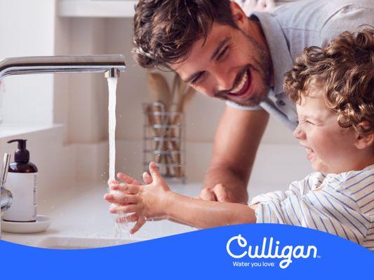 Father and Son at Kitchen Sink with Culligan Filtered Water