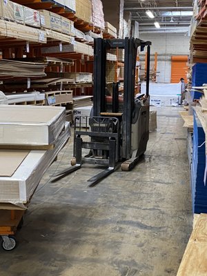 An unattended forklift in an aisle.