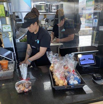 Two staff members counting the cash drawers, one of which is on a cutting board where food is prepped.