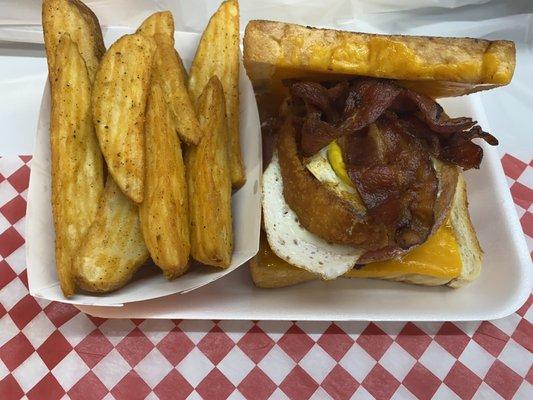 Fried egg, bacon, pork roll, onion ring on a Patti melt with wedges