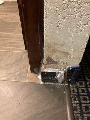 Crappy patchwork on baseboard near bathroom