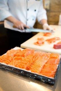 Chef cutting fresh salmon at catering