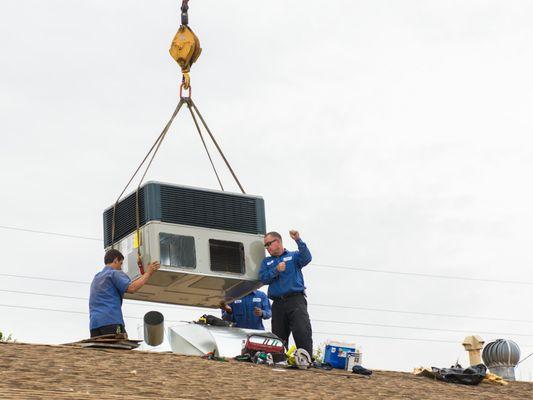 John and crew guiding the new unit into place.